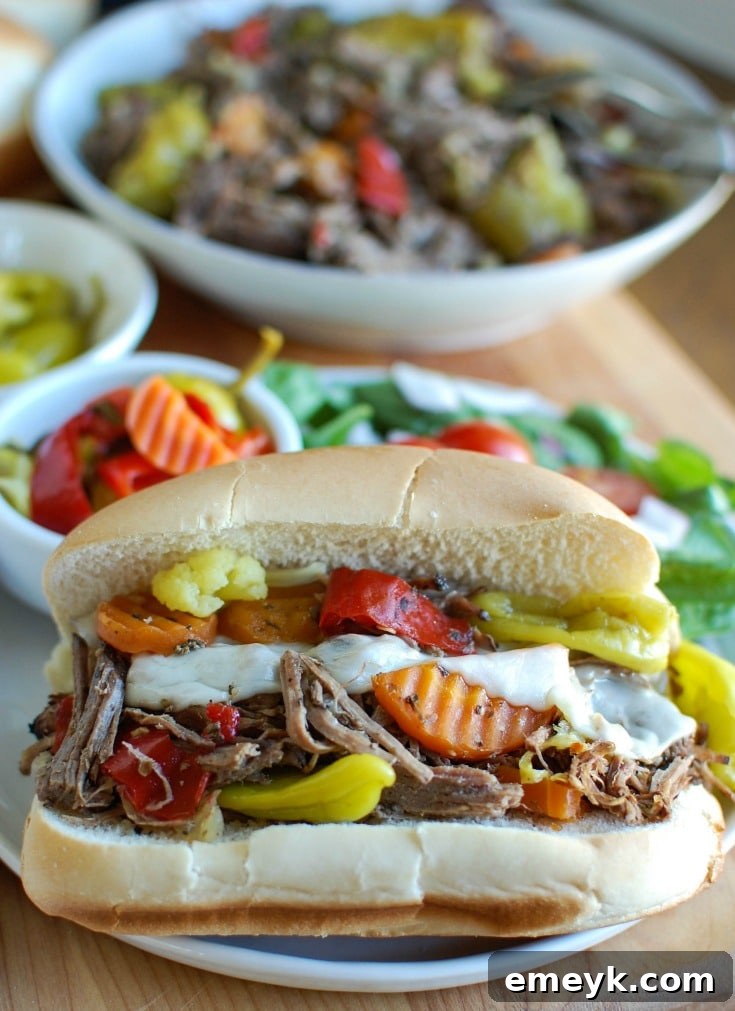 Slow Cooker Italian Beef Sandwiches make a great game day food or weeknight dinner that easily cooks in your crockpot. Chuck roast is slowly cooked in Italian seasonings, beef broth and mixed with pepperoncini peppers and Giardiniera. Toast the beef in a hoagie bun with provolone cheese and extra pepperoncini and Giardiniera for the perfect sandwich.