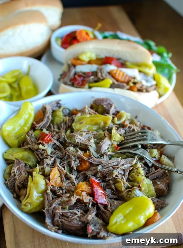 Slow Cooker Italian Beef Sandwiches make a great game day food or weeknight dinner that easily cooks in your crockpot. Chuck roast is slowly cooked in Italian seasonings, beef broth and mixed with pepperoncini peppers and Giardiniera. Toast the beef in a hoagie bun with provolone cheese and extra pepperoncini and Giardiniera for the perfect sandwich.