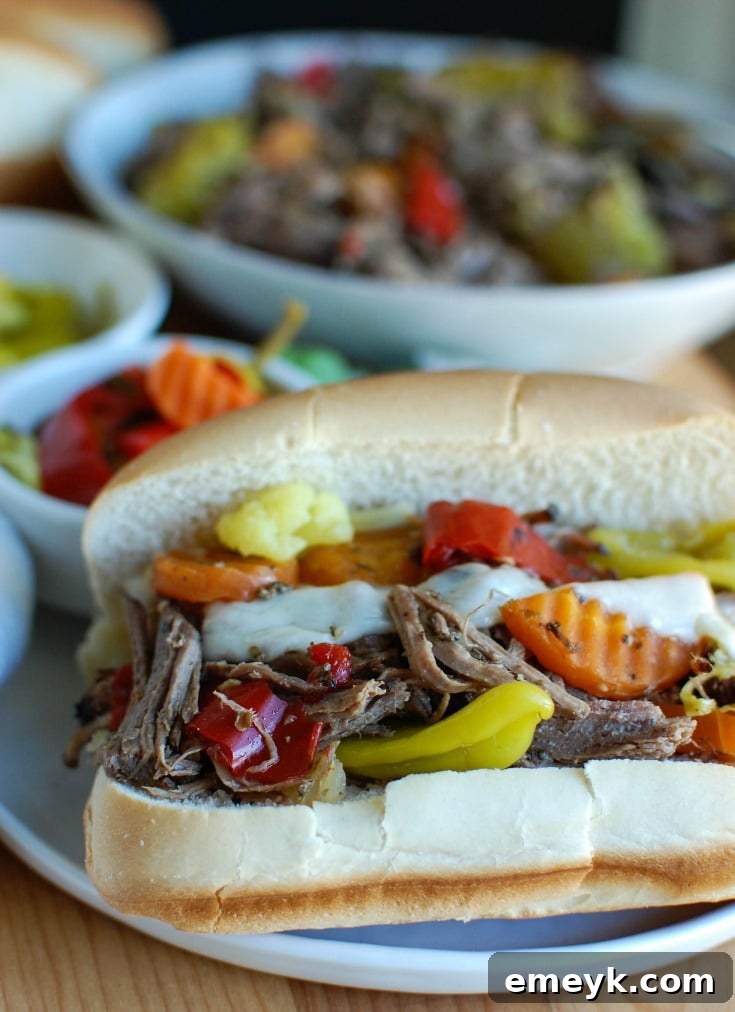Slow Cooker Italian Beef Sandwiches make a great game day food or weeknight dinner that easily cooks in your crockpot. Chuck roast is slowly cooked in Italian seasonings, beef broth and mixed with pepperoncini peppers and Giardiniera. Toast the beef in a hoagie bun with provolone cheese and extra pepperoncini and Giardiniera for the perfect sandwich.