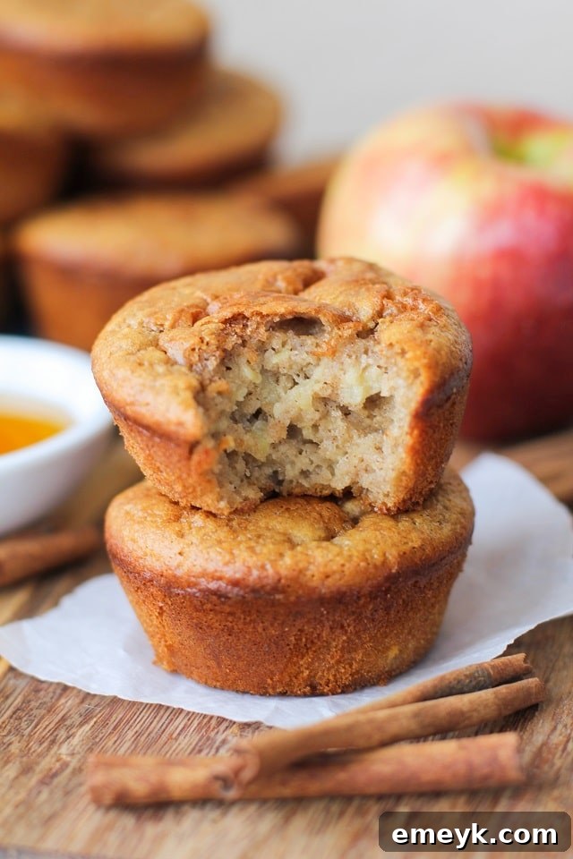 Golden-brown, grain-free apple cinnamon muffins, freshly baked and topped with a sprinkle of cinnamon.
