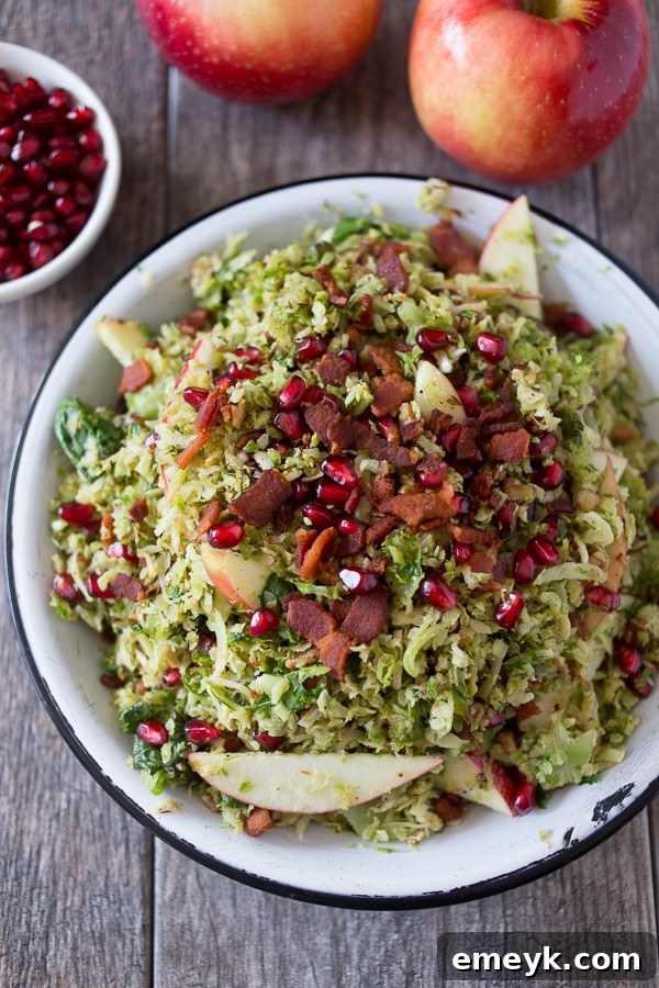 A vibrant shaved brussels sprout, apple, and bacon salad, tossed with a light dressing and sprinkled with nuts.