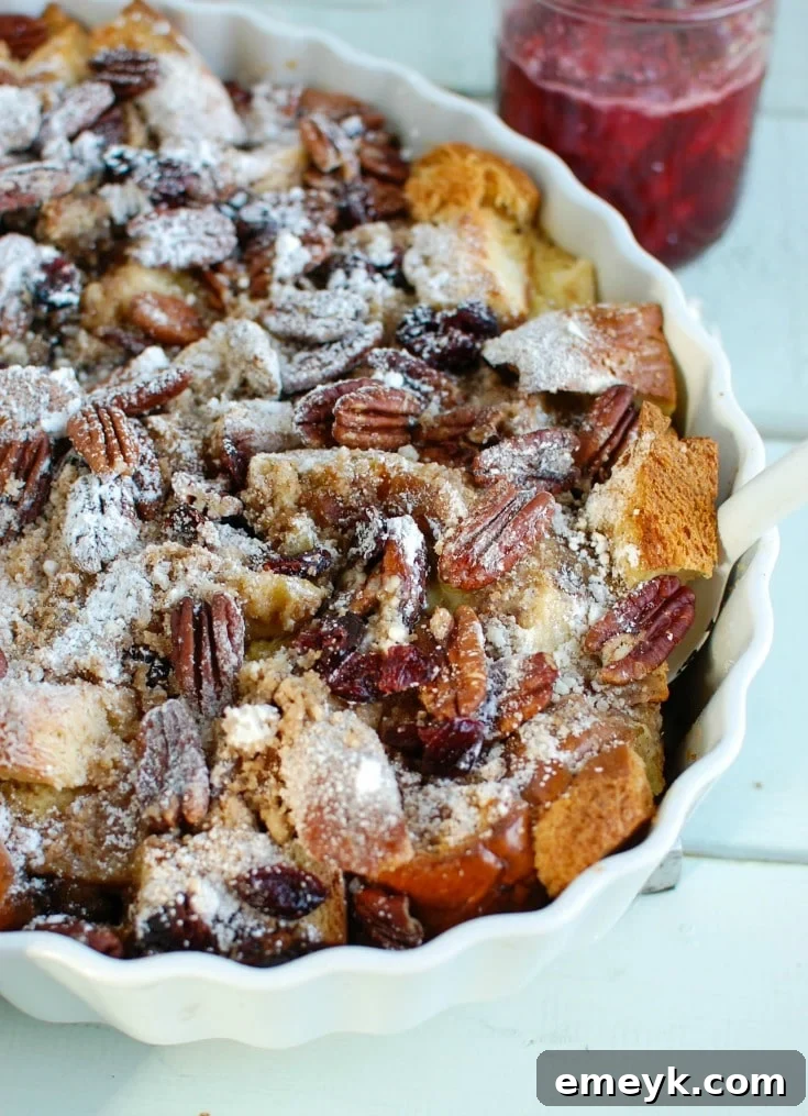 Collection of fresh ingredients for Overnight Eggnog French Toast Bake, including bread, eggnog, cranberries, and spices.