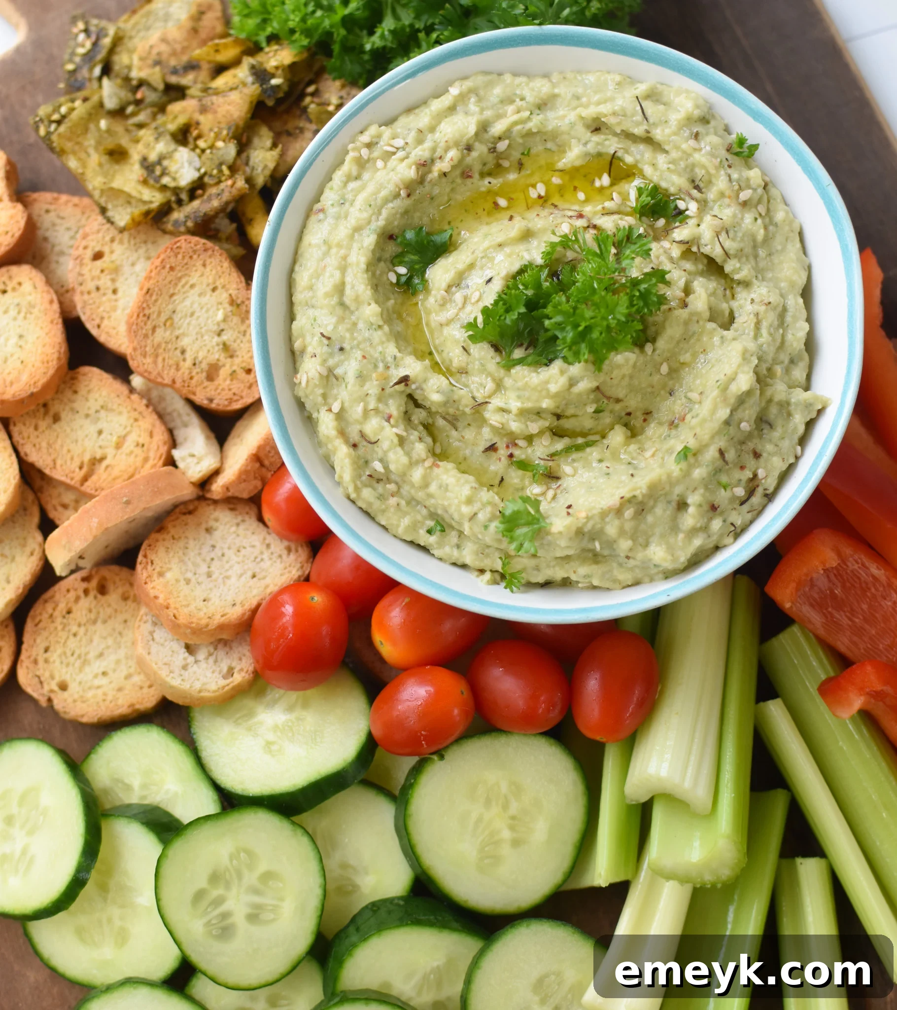 White Bean Artichoke Dip with assorted fresh vegetables, arranged beautifully for serving.