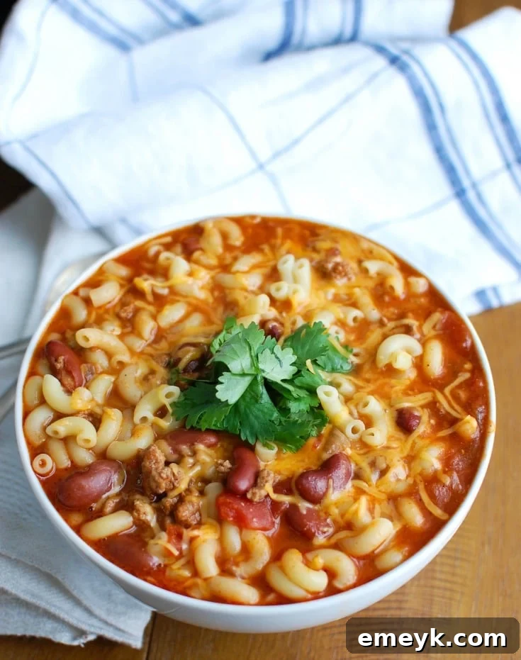 A delicious bowl of Crock-Pot Turkey Chili Mac and Cheese, garnished with fresh cilantro, ready to be enjoyed. Perfect comfort food for cold weather.