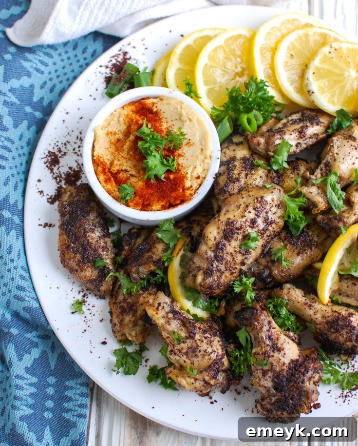 Crispy, golden-brown Sumac Lemon Baked Chicken Wings garnished with fresh parsley and lemon slices, ready to be served.