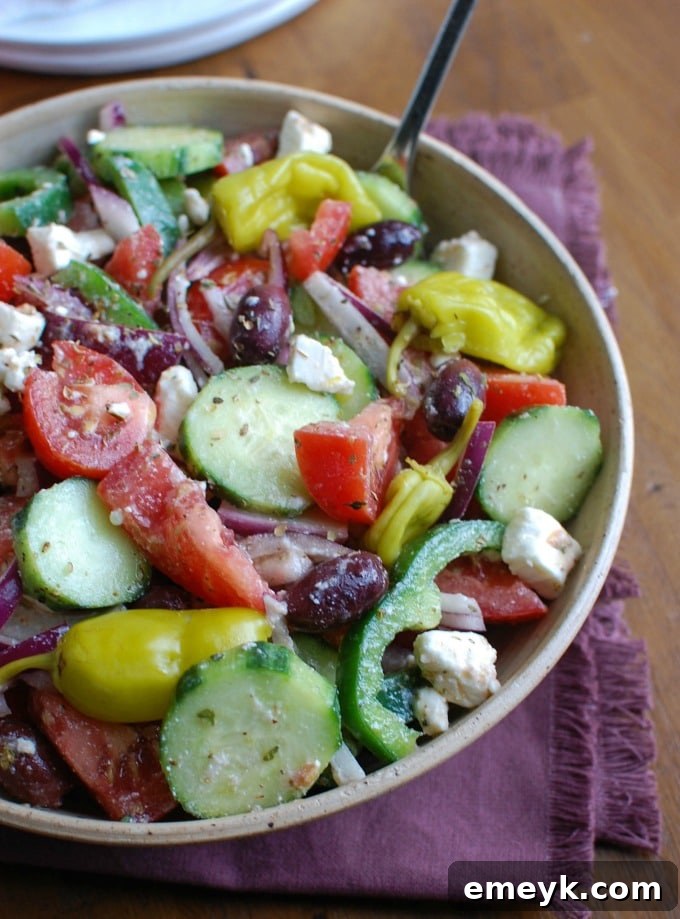 A fresh and vibrant Greek Village Salad, brimming with healthy vegetables, tangy feta cheese, Kalamata olives, and zesty pepperoncinis.