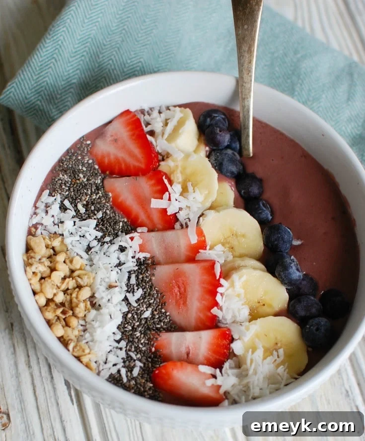 A vibrant Chia Seeds Fruit Bowl garnished with fresh berries and coconut flakes, served with a blue napkin.
