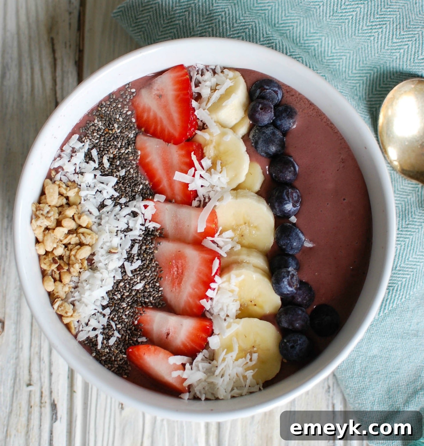 A visually appealing Chia Seeds Fruit Bowl with a spoon, garnished with fresh fruit and a patterned napkin.