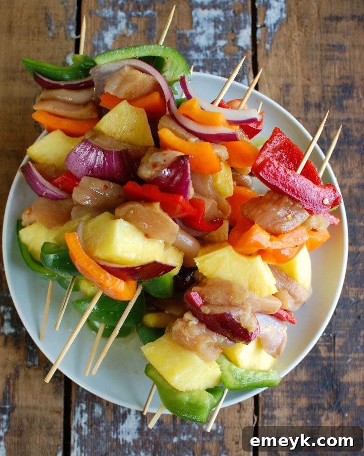 Grilled Hawaiian Chicken Kabobs on a white plate, garnished with fresh herbs