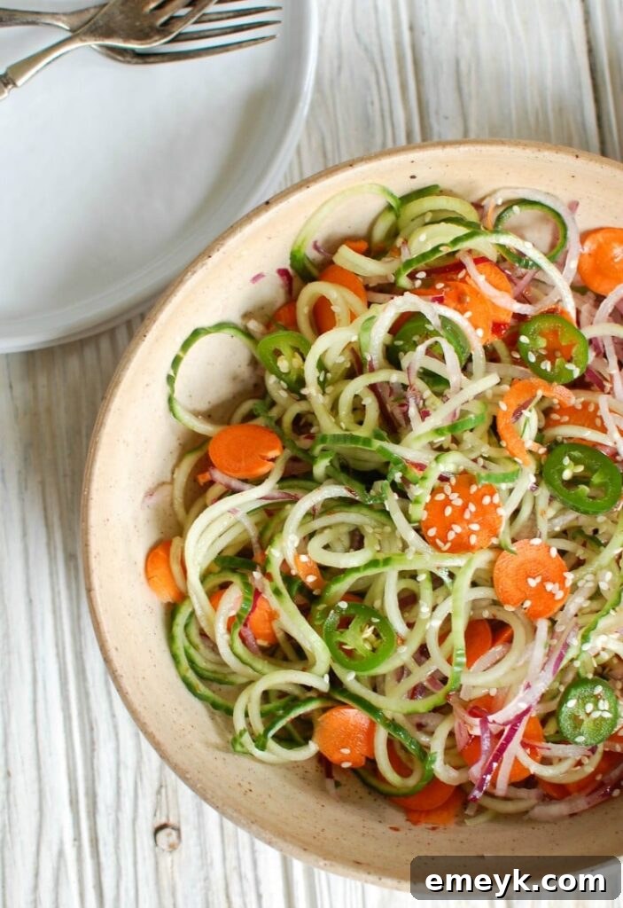 Close-up of fresh Asian Cucumber Noodle Salad with vibrant colors, showcasing the spiralized vegetables and light dressing.