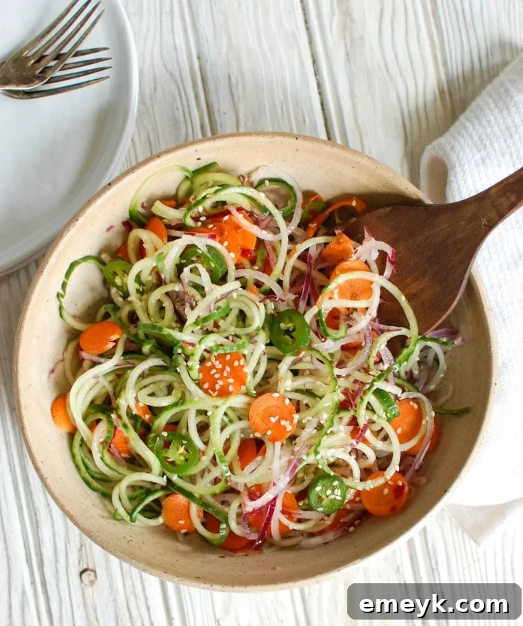 Prepared Asian Cucumber Noodle Salad in a bowl, showing the mix of colorful spiralized vegetables and the glistening dressing.