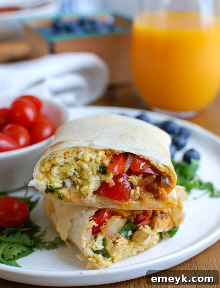Close-up of a partially wrapped Vegetarian Breakfast Egg Burrito, showing the delicious filling.