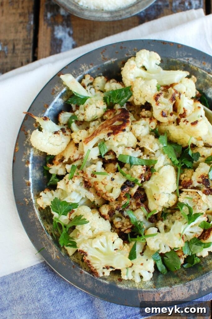 Roasted Parmesan Garlic Cauliflower is the perfect side dish the whole family will love. Cauliflower, olive oil, garlic and parmesan cheese take normal cauliflower to the next level. 