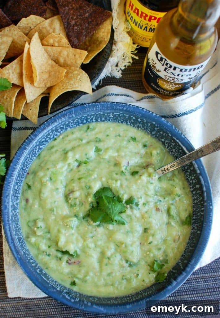 Avocado Tomatillo Salsa served with tortilla chips and a drink.