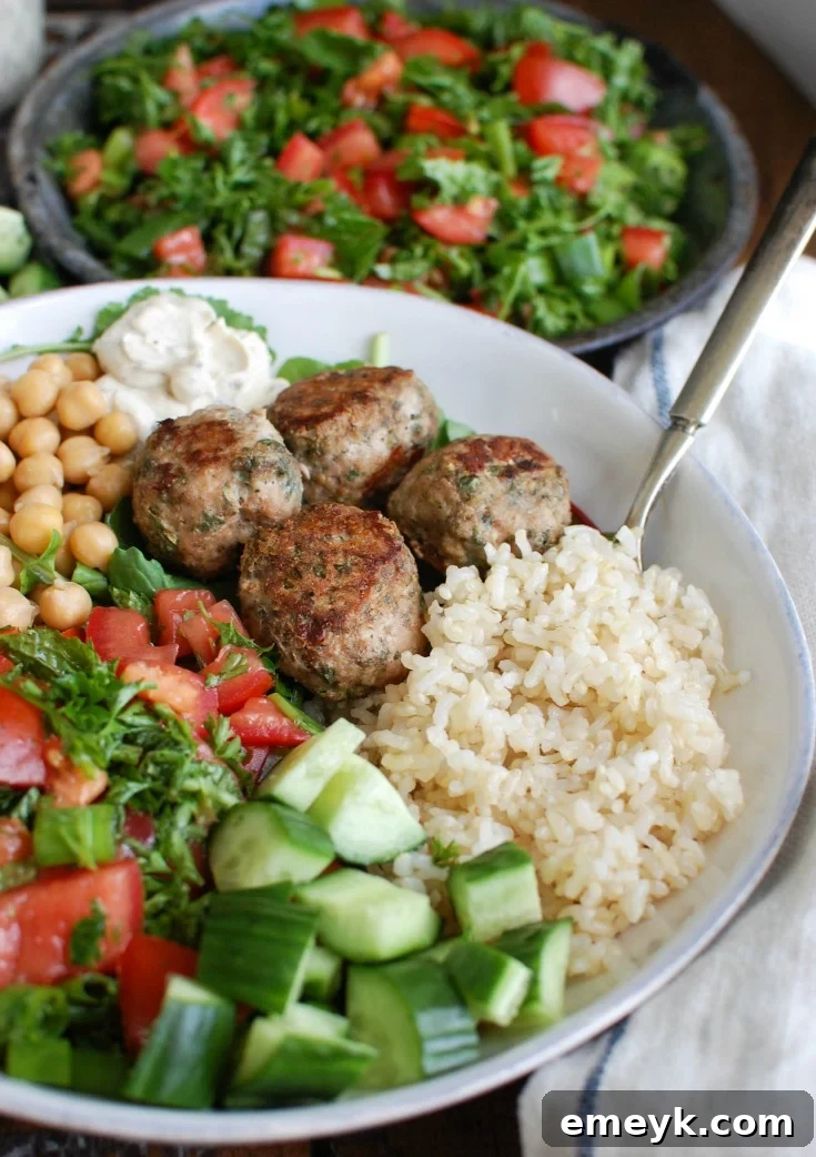 A bowl of Mediterranean Baked Turkey Meatballs, garnished with fresh herbs and ready to serve.