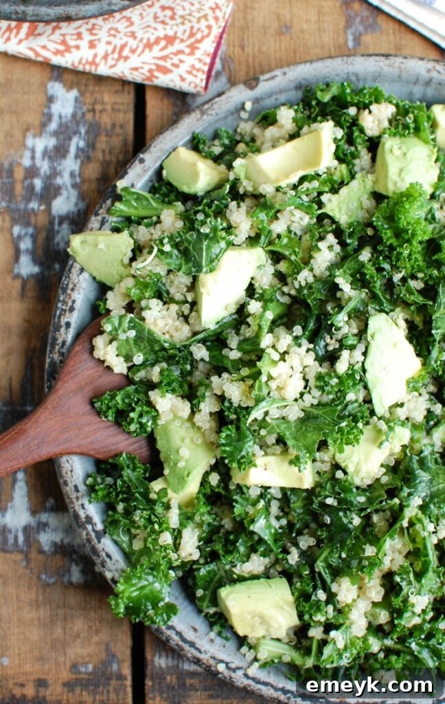 A beautifully composed Avocado Kale Quinoa Salad, showcasing tender massaged kale, creamy avocado slices, and fluffy quinoa, glistening with a light lemon dressing in a large serving bowl.