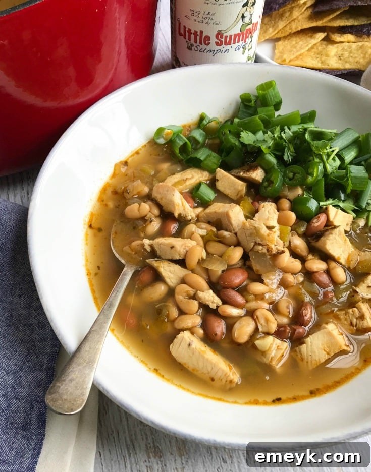 Close-up of Green Chicken Chili bubbling in a pot, showcasing the rich texture and vibrant green chiles.