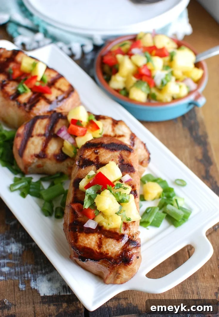 Aloha Grilled Pork Chops 5 A close-up of a Grilled Hawaiian Pork Chop topped with colorful pineapple salsa, showcasing the fresh ingredients and appetizing presentation.
