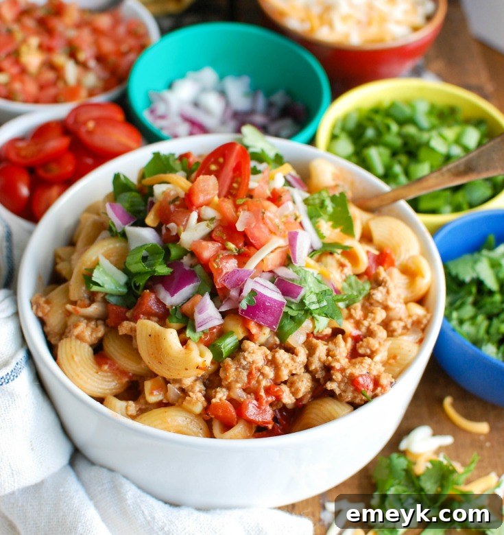 Instant Pot Turkey Taco Pasta ready to be served, topped with fresh cilantro and cheese.