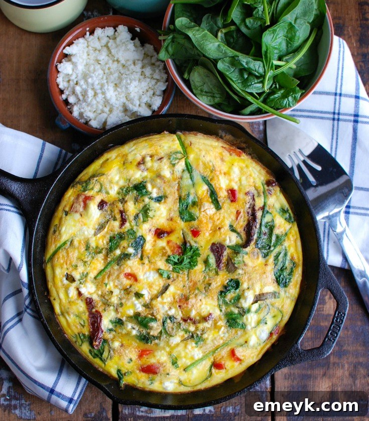 A slice of Sun-Dried Tomato Goat Cheese Frittata on a plate, showing off its rich texture and colorful ingredients, ready to be enjoyed.