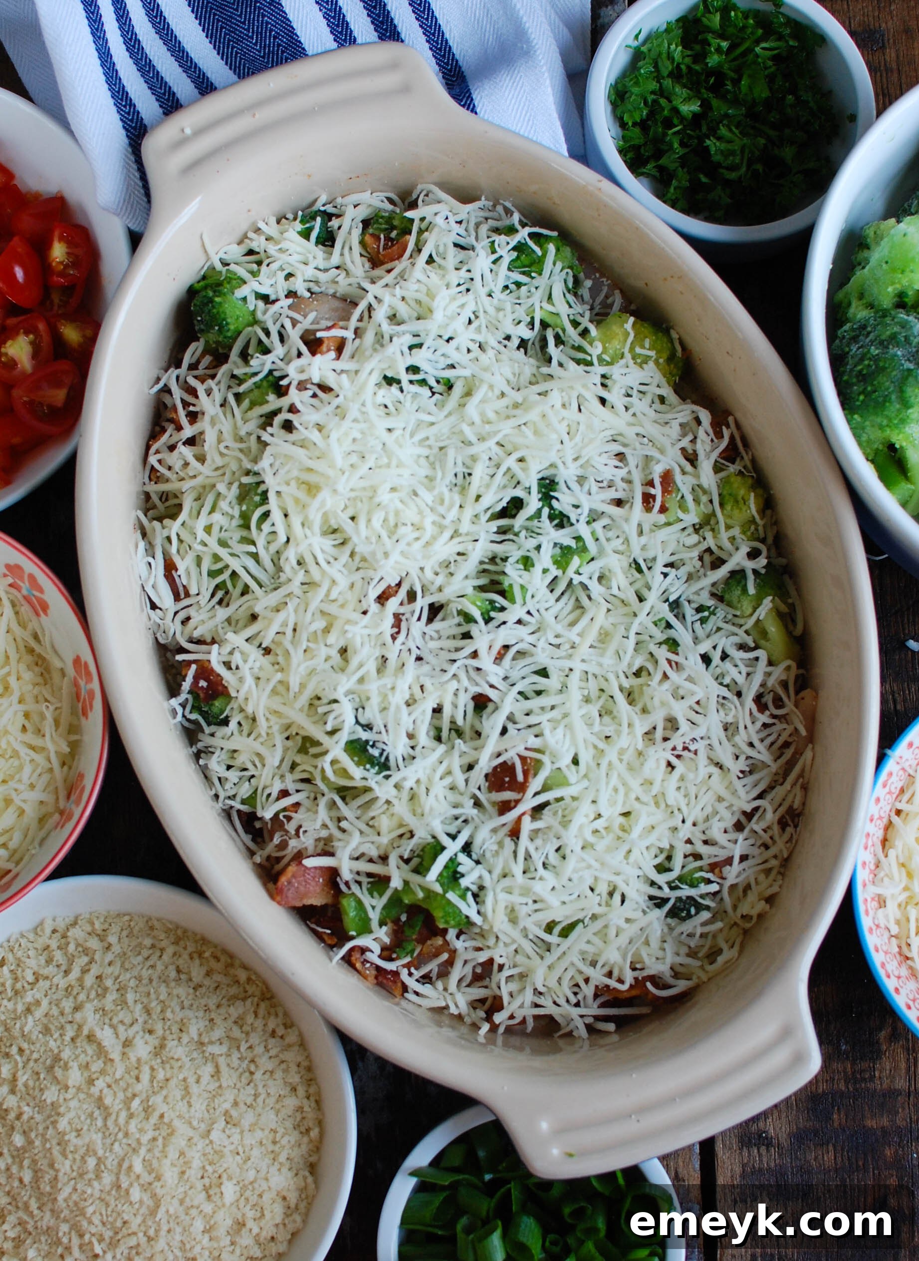 Cheesy Chicken and Broccoli Bake 6 A casserole dish brimming with seasoned chicken, broccoli, and bacon, generously topped with a blend of Sargento shredded cheese and crunchy panko breadcrumbs, ready for the oven.