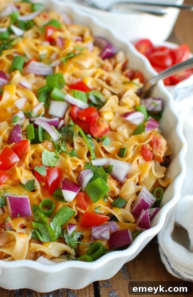 Close-up of the Mexican Noodle Casserole showing the rich texture of the noodles, ground turkey, and vibrant vegetables mixed with cheese.