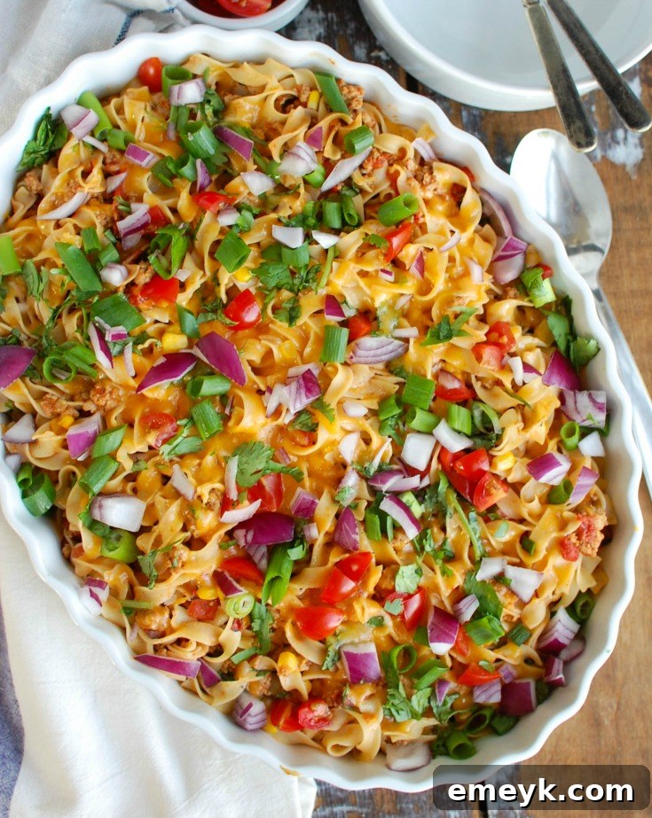 The finished Easy Mexican Noodle Casserole, baked until golden and bubbling, garnished with fresh toppings and ready to serve.