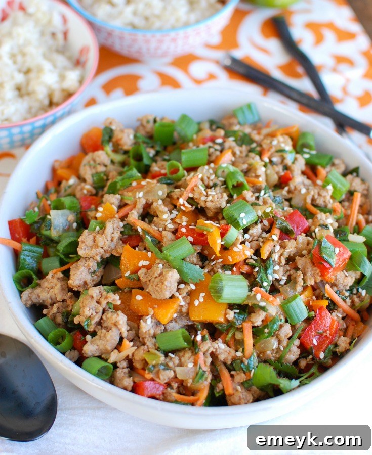 A bowl of Easy Thai Pork Stir-Fry with extra vegetables and garnishes, showcasing customization options