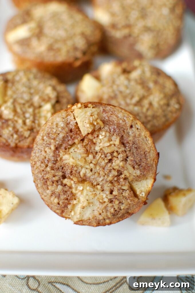 Spiced Apple Steel Cut Oat Muffins 3 A selection of warm Baked Apple Cinnamon Steel Cut Oat Cups displayed on a rustic wooden board, emphasizing their wholesome and inviting texture.