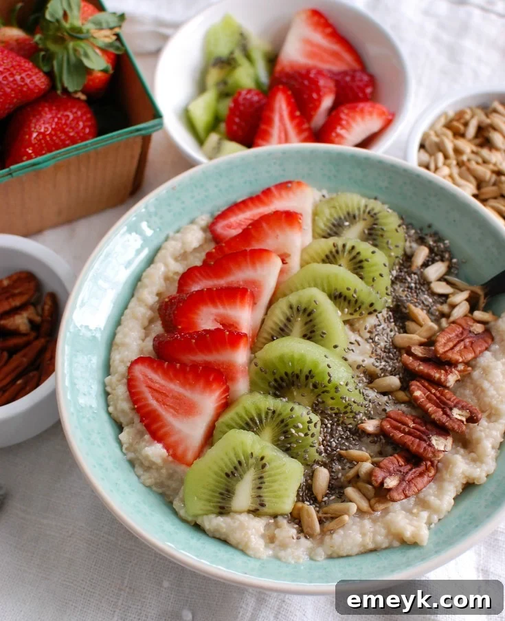 Close-up shot of a creamy oat bran bowl adorned with sliced strawberries, kiwi, and a dusting of chia seeds, highlighting the fresh ingredients and inviting texture.