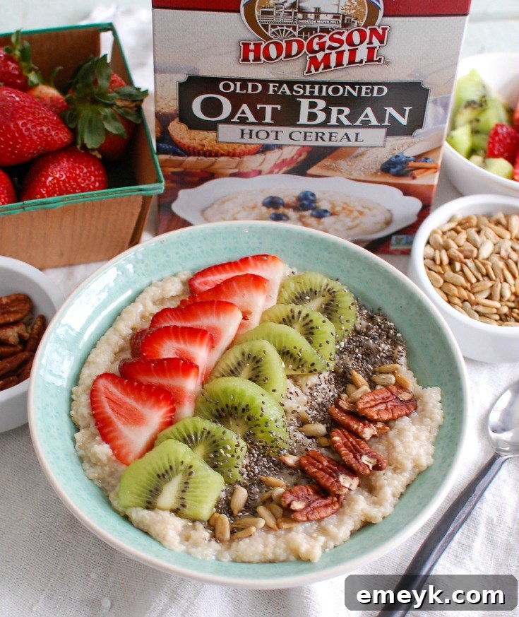 Overhead shot of an oat bran bowl, generously topped with an abundance of fresh strawberries, bright kiwi, and a harmonious mixture of chia seeds and crunchy nuts, perfectly composed and ready to be enjoyed.