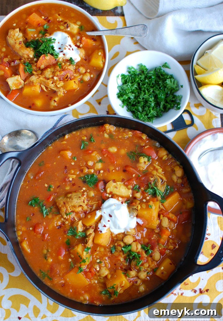 Slow Cooker Moroccan Chicken Soup simmering gently in a black crockpot, filled with succulent chicken, tender lentils, and a colorful array of vegetables.