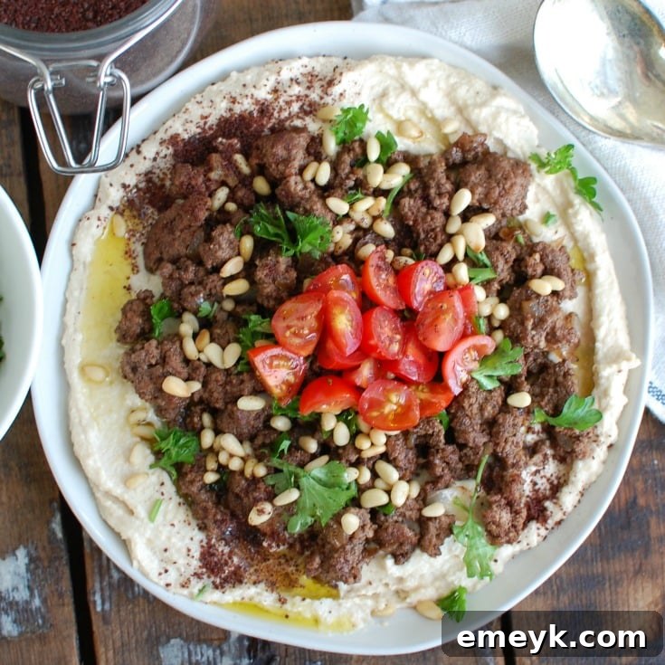 A serving of Hummus with Spiced Beef and Toasted Pine Nuts, showing the rich texture and vibrant colors of the dish.