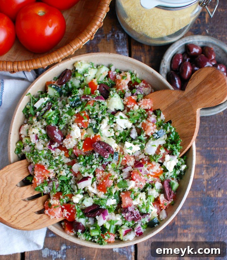 Greek Tabbouleh served in a bowl with serving spoons, highlighting its fresh components.