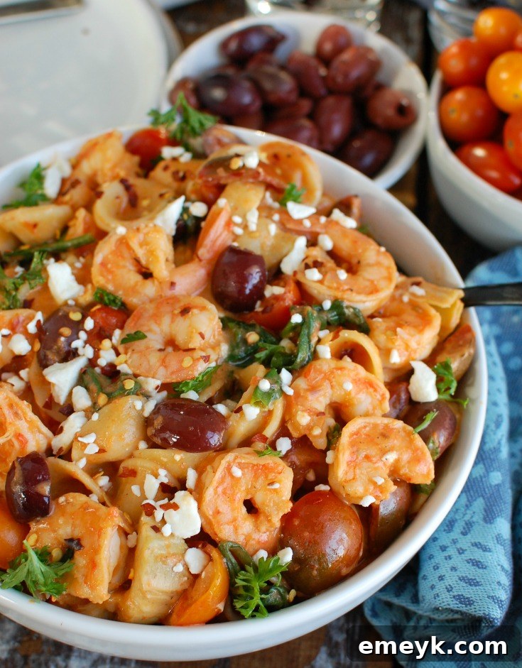 A bowl of freshly made One Pot Mediterranean Shrimp Pasta, garnished with fresh parsley and red pepper flakes, ready to be served.