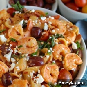 One Pot Mediterranean Shrimp Pasta served in a white bowl, garnished with fresh herbs, close-up shot.