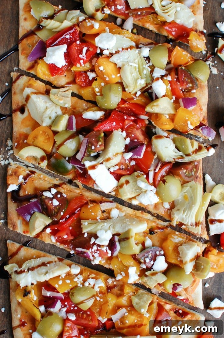 Mediterranean Flatbread is a quick and easy vegetarian meal made on your favorite flatbread or naan. Your favorite Mediterranean flavors of hummus, olives, artichokes, roasted peppers, feta cheese, tomatoes, red onion and balsamic glaze create a colorful, flavor packed appetizer or meal. 