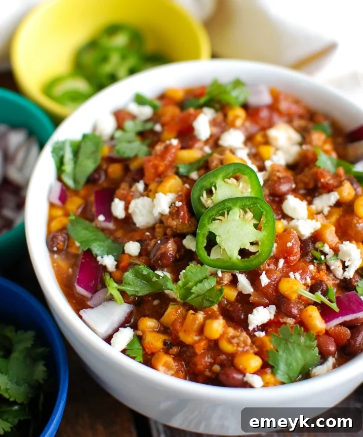 Instant Pot Pork Chili in white bowl with toppings