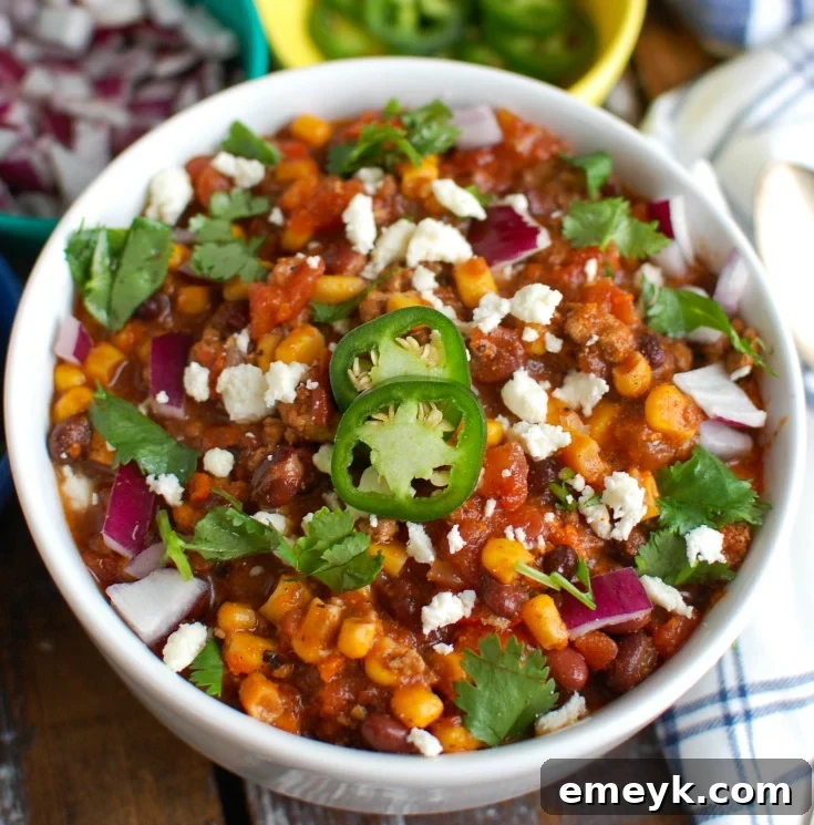 A bowl of Instant Pot Pork Chili, garnished and ready to eat