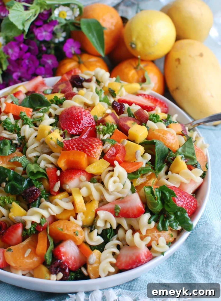 Bright Spring Pasta Salad 2 A vibrant Spring Pasta Salad featuring colorful fusilli, fresh mango, strawberries, and mandarins, presented as a perfect side dish for a spring brunch or summer picnic.