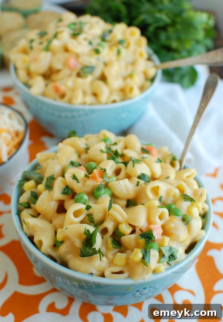 Instant Pot Vegetable Mac and Cheese in a vibrant blue bowl, ready to be enjoyed with a spoon.
