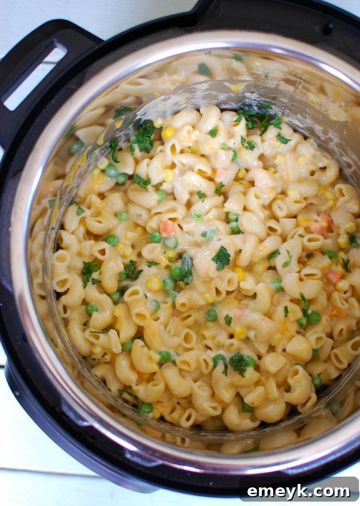 Instant Pot Vegetable Mac and Cheese cooking inside the Instant Pot, showing the pasta and sauce before the final mix.