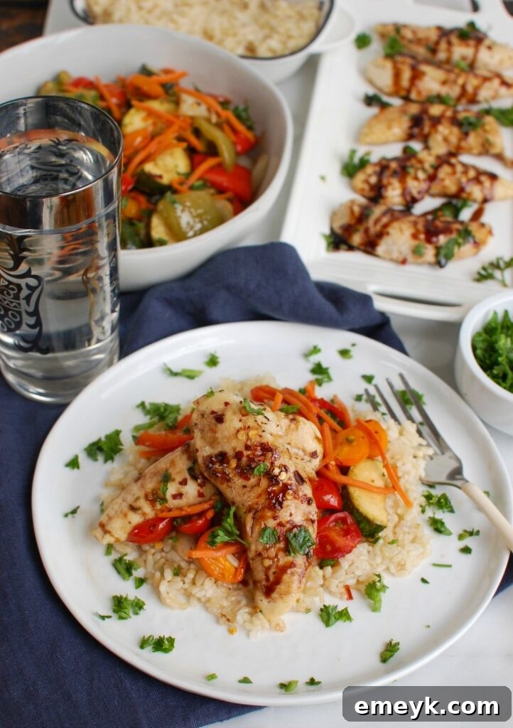 Sheet Pan Honey Balsamic Chicken Tenders and Vegetables artfully arranged on a white plate, ready to be served.