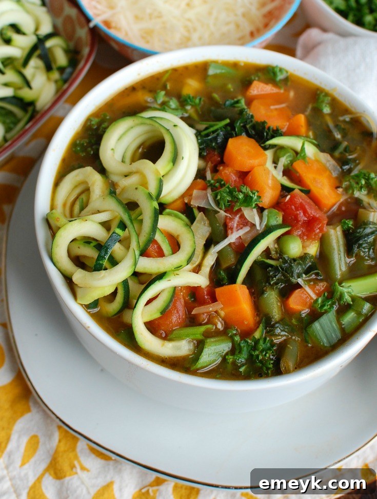 Garden Fresh Spring Minestrone 2 Spring Vegetable Minestrone in a white bowl, garnished with fresh herbs, viewed from the side, showcasing its rich texture and colorful vegetables.