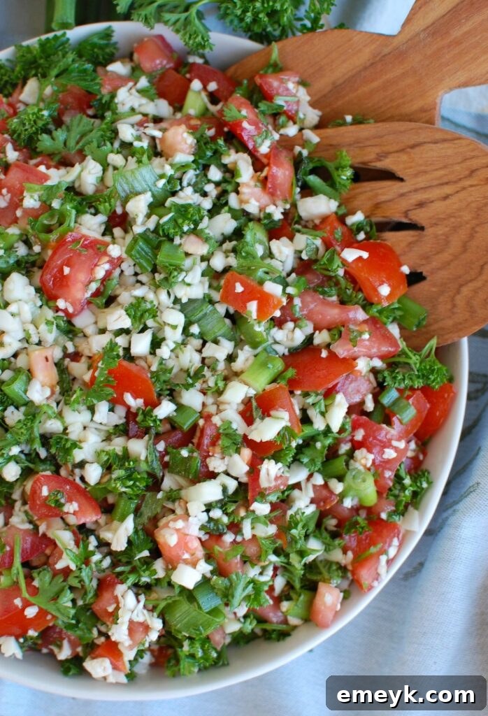 Grain-Free Cauliflower Tabbouleh 3 Fresh ingredients for Cauliflower Tabbouleh laid out, including cauliflower, tomatoes, and herbs.