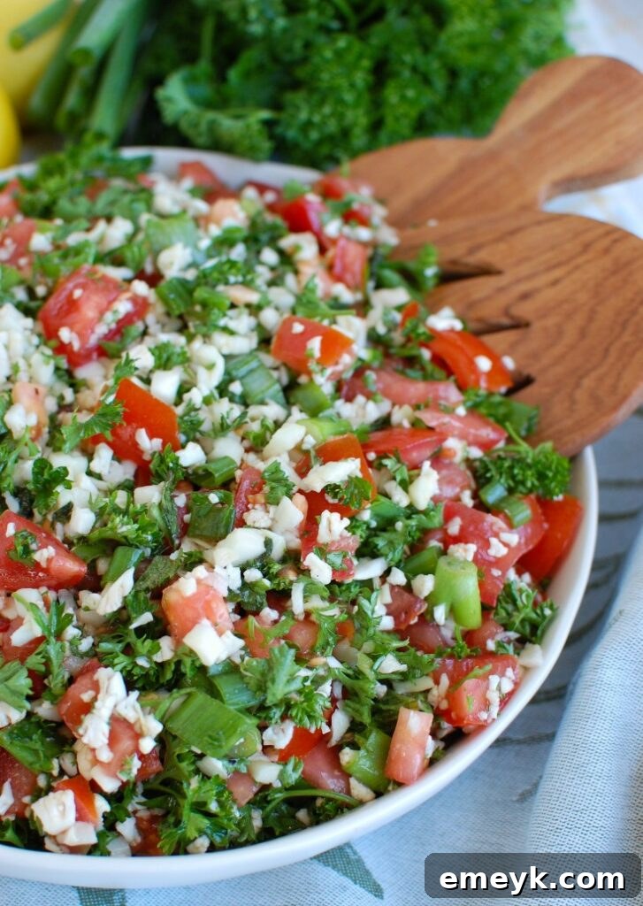 Grain-Free Cauliflower Tabbouleh 4 Cauliflower Tabbouleh in a bowl with a wooden spoon, ready to serve.