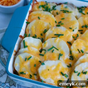 Spinach Artichoke Scalloped Potatoes in a blue baking dish, a perfect holiday side.