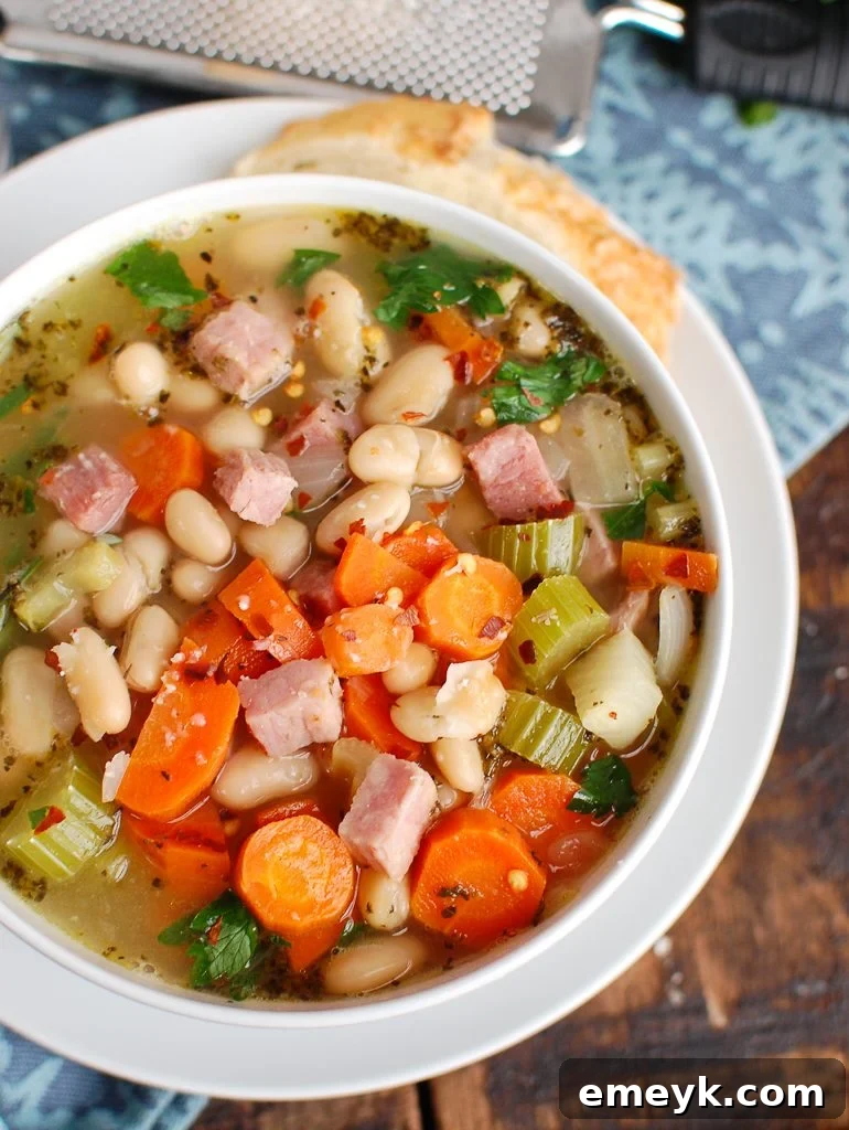 White Bean and Ham Soup served in a white bowl with herbs