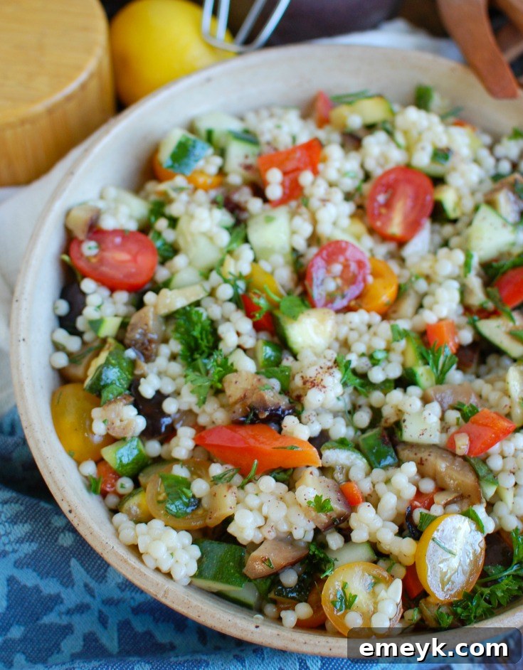 Large white bowl filled with Mediterranean Grilled Vegetable Couscous Salad, ready to serve.