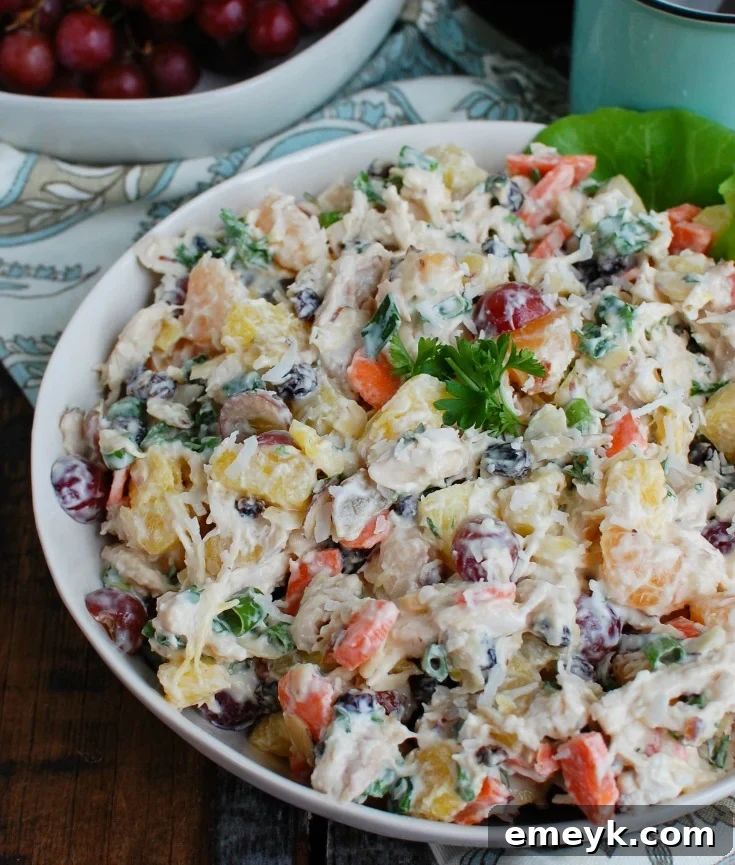 Island Escape Chicken Salad 2 Tropical Chicken Salad in a pristine white bowl, garnished with fresh herbs and a slice of lime. A vibrant, healthy meal idea for summer.